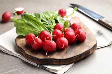 Many fresh radishes on grey textured table, closeup