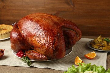 Whole baked turkey and other dishes served on wooden table