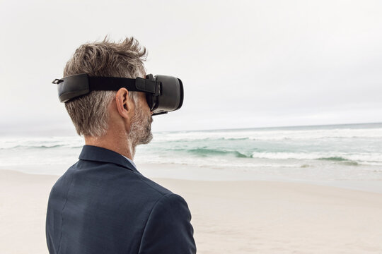 Businessman using VR glasses on the beach, Nordhoek, Western Cape, South Africa