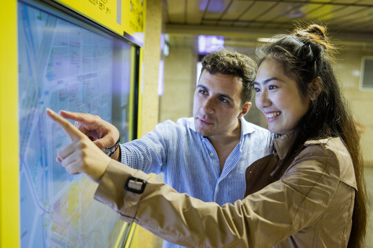 Couple checking map at Ginza underground station, Tokyo, Japan