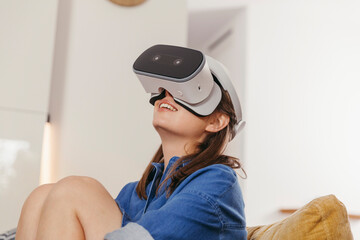 Young woman using VR glasses at home