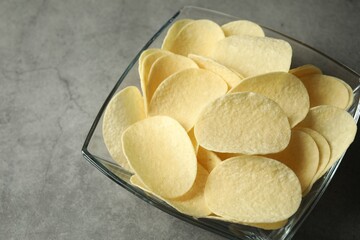 Tasty potato chips on grey table, closeup