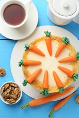Delicious homemade carrot cake served on light blue wooden table, flat lay