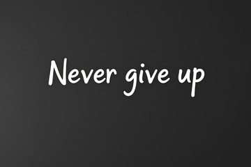 White text Never give up on black chalkboard