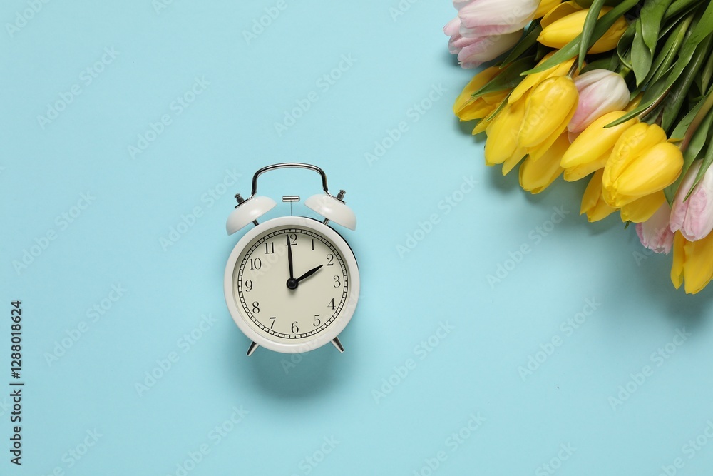 Poster spring time. alarm clock and beautiful tulips on light blue background, flat lay