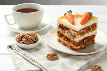 Piece of delicious homemade carrot cake served on white wooden table, closeup