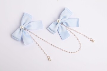Beautiful hair bows with beads on white background, top view