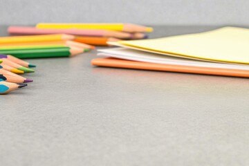 Colorful pencils and sheets arranged neatly on gray surface, ins