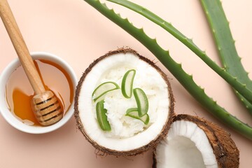 Hair treatment. Coconut, butter shavings, honey and aloe leaves on beige background, flat lay