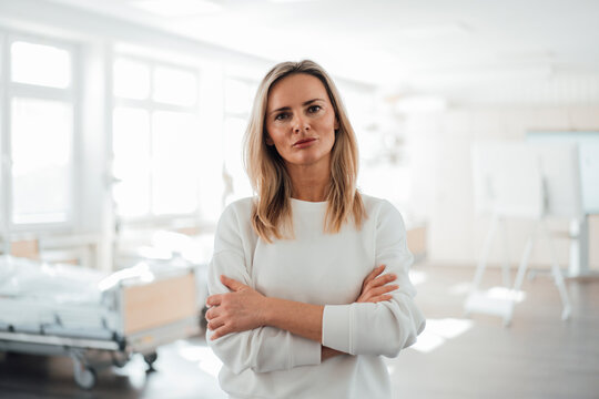 Doctor standing confidently in a clinic patient room