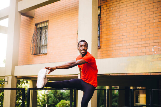 Young sportive man doing stretching exercise outdoors