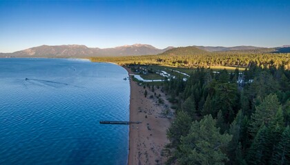 Aerial view of a serene Baldwin Beach lake shore with a sandy beach, a pier, and lush forest. Quiet...
