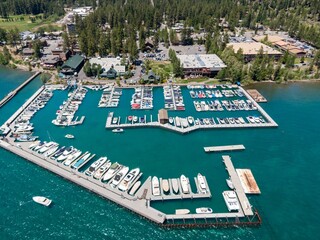 Aerial view of a bustling Lake Tahoe marina. Many boats are docked, and the surrounding area has...