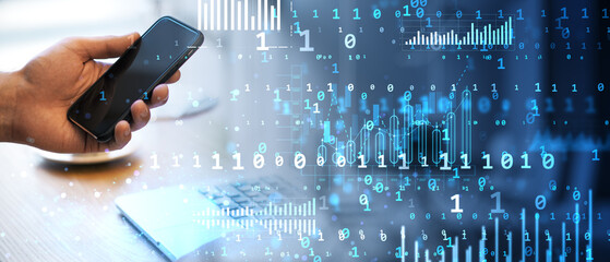 Hand holding smartphone with digital data overlay on office desk background.