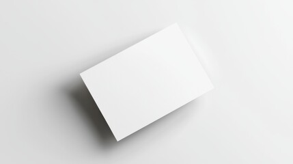 Blank white business card on a flat light surface, ready for branding or design mockup.