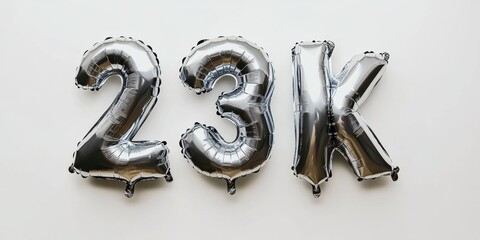 Silver foil balloons spelling 23k on white background