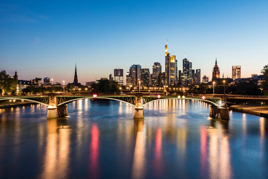 Illuminated Ignatz Bubis Bridge over River Main against sky during dusk, Frankfurt, Germany