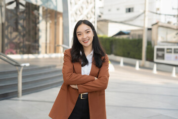 Obraz premium Portrait of a successful business woman standing in front of modern business building.
