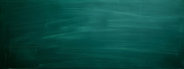 Dark green chalkboard with chalk marks and scratches. School and learning concept. Background for education projects, teaching materials and academic presentations. Banner with copy space.