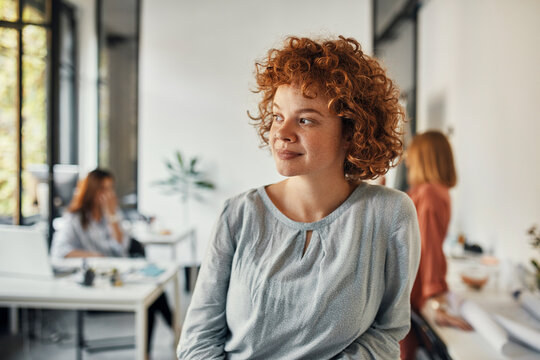 Portrait of a redheaded businesswoman in office looking sideways