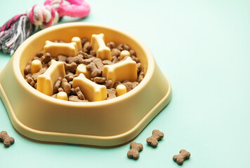 Yellow slow feeder bowl with dog kibble and toy