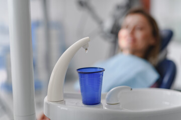 Dental rinse cup with water dispenser at dentist's office.