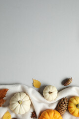 Beautiful autumn composition with pumpkins and leaves on soft beige fabric