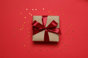 Beautiful gift box with confetti on color background 