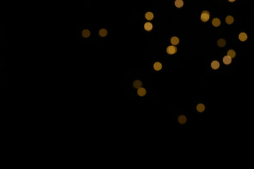 Golden blurred bokeh lights on black background. Glitter sparkle stars for celebrate. Overlay for...