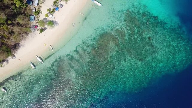 Seven Commandos beach, Palawan. Aerial view of beautiful white sand beach, with palm trees and filipino boats in Siete Pecados Beach, Palawan, Philippines. 