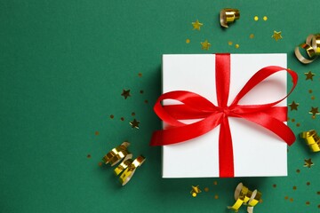 Beautiful gift box with confetti on color background 