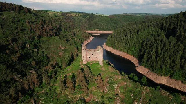 aerial shot going forward revealing Alleuze Castle and the Truyere river in the background on a partially cloudy day of summer, cantal departement, Auvergne Rhone Alpes region, France