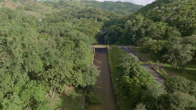 Aerial View Of Hatillo Dam Downstream Channel Along The Green Forest.