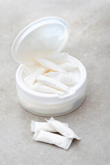 a white container of nicotine pouches on a grunge gray surface