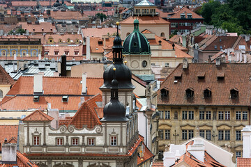 View of the city's red tile roofs and domes in old Prague from the wall of Prague Castle.