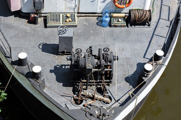Top view of the deck of a river boat with rigging, ropes and chains.