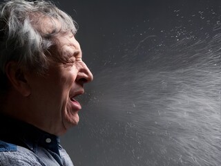 Man Sneezing Dramatically Highlighting Airborne Droplets in Profile View