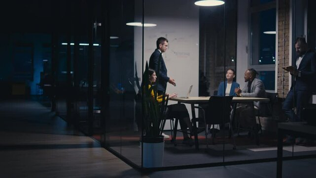 Diverse business team in modern office during a late-night meeting. Professional discussion on artificial intelligence strategy. Concept of corporate teamwork, innovation, and AI technology. - Powered by Adobe