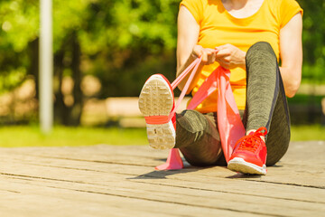 Girl doing exercise outdoor, using resistance fit band.