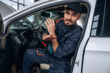 This doesn't work, hands crossed. Mechanic is in a car service station
