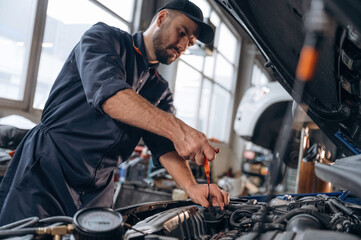 Transport is being repaired. Mechanic working in a car service station