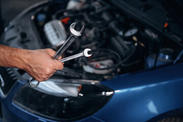 Blue automobile, working. Close up view of mechanic in car service station