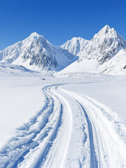 Obraz premium Serene winter landscape with snow-covered mountains and a winding trail. Perfect for winter sports and adventures!