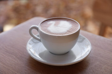 Fototapeta premium Cup of aromatic coffee on wooden table in cafe, closeup