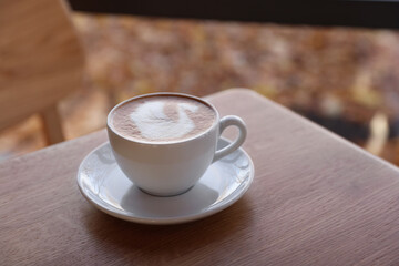 Cup of aromatic coffee on wooden table in cafe, closeup