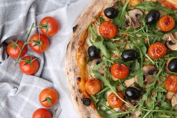 Tasty pizza with cherry tomatoes, black olives, mushrooms and arugula on table, flat lay