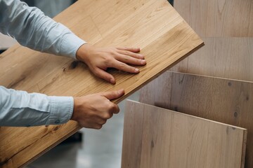 Surface of the parquet. Detailed close up view of man's hand in the hardware store