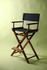 One empty director's chair on pale olive background
