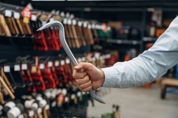 Crowbar in hand. Detailed close up view of man's hand in the hardware store