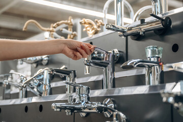 Bathroom tap. Close up view of woman that is in the hardware store